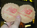 Two New Balance branded waffles held by a hand against a blurred background