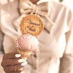 Ice cream cone with a personalized waferr label held by a person wearing a bow tie.